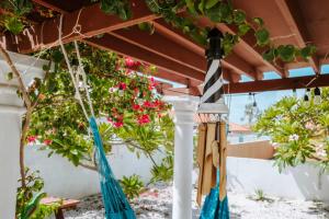 two hammocks hanging from a pergola at Casa del Sol, 2-Bedroom Home Near Palm Beach in Noord +10 photos