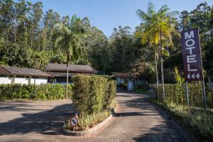 a sign for a motel next to a road at MOTEL 3 PEIXINHOS (Adults Only) in Blumenau