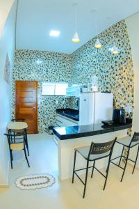 Il comprend une cuisine équipée de 2 chaises, d'une table et d'un réfrigérateur. dans l'établissement Conforto em Boa Vista com varanda e garagem privado, à Boa Vista