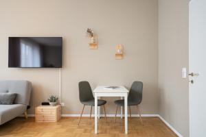 グラーツにあるBoho Living Studio - Historic City Center with Free Parking by HERO HOMESのリビングルーム(白いテーブル、椅子2脚付)