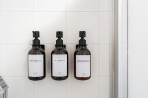 3 bottiglie su una mensola in bagno di Boho Living Apartments - Historic City Center with Free Parking by HERO HOMES a Graz Altre 46 foto