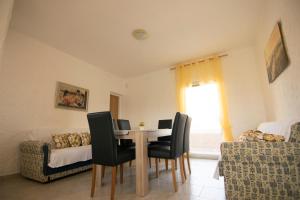 Un comedor con una mesa y sillas y un sofá. en Villa Veronika, en Nin