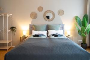 グラーツにあるBoho Living Studio - Historic City Center with Free Parking by HERO HOMESのベッドとタオル2枚のある寝室