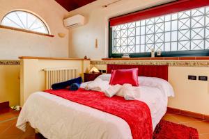 une chambre avec un grand lit avec une couverture rouge et blanche dans l'établissement Villa Artemisia, Porzione di villa, luxury vila, à Padenghe sul Garda