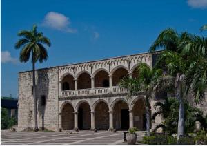 a large stone building with palm trees in front of it at JEYMAR STUDIO rd in Santo Domingo