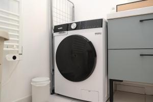 a white washing machine in a white kitchen at Lumineux T3 - 2 chambres, balcon - proche de Rouen in Le Petit-Quevilly