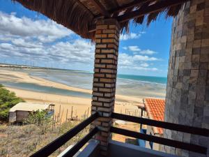 a view of the beach from a balcony of a beach house at Pousada Vista do Pôr do Sol in Areia Branca