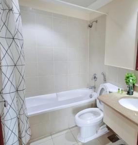 Un baño con bañera, inodoro y lavabo. en شقة منتزة المارينا, en King Abdullah Economic City 27 fotos más