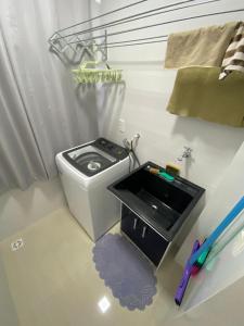 a bathroom with a toilet and a sink in a room at Apartamento ACONCHEGANTE para família em Piratuba - Brisa Do Sol - Apto 401 in Piratuba