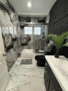 a bathroom with a tub and a toilet and a sink at LUXURY VILLA Estate Oasis in Downey