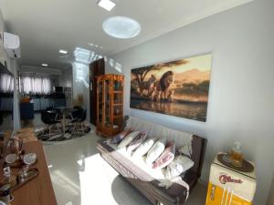 a living room with a couch and a painting on the wall at Apartamento ACONCHEGANTE para família em Piratuba - Brisa Do Sol - Apto 401 in Piratuba