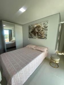 a bedroom with a bed with a painting on the wall at Apartamento ACONCHEGANTE para família em Piratuba - Brisa Do Sol - Apto 401 in Piratuba