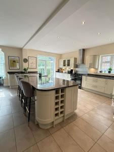 a large kitchen with a large island in the middle at Spacious 6 Bedroom house, Luton in Luton