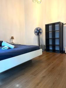 a bedroom with a blue bed and a fan at Petit Patapon - T2 Hyper Centre in Albi