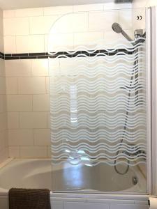 a shower curtain in a bathroom with a tub at Petit Patapon - T2 Hyper Centre in Albi +24 photos