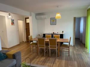 a dining room and living room with a table and chairs at Perle rare, F4 donnant sur un grand jardin privé aménagé, parkings gratuits, clim, calme, idéal famille & pro, 10 min de la mer et du centre-ville, de la gare sncf et routière in Toulon