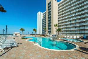 a swimming pool with chairs and a building at Laketown Wharf 331 in Panama City Beach