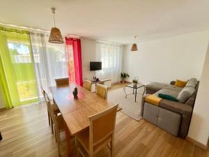 a living room with a table and a couch at Perle rare, F4 donnant sur un grand jardin privé aménagé, parkings gratuits, clim, calme, idéal famille & pro, 10 min de la mer et du centre-ville, de la gare sncf et routière in Toulon