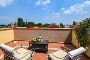 a patio with two chairs and a table on a balcony at Villa Artemisia - Villa Luxury 300m dal lago, Piscina salata, idromassaggio in Padenghe sul Garda