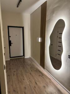an empty room with a mirror and a hallway at Уютная студия в жк Four Seasons in Zhezdi