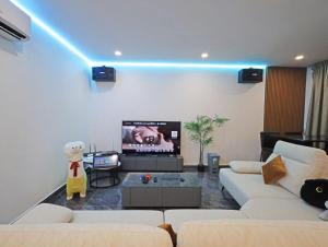 a living room with a couch and a tv at 30 PAX Perling Party House #Miao Nalisa# in Johor Bahru