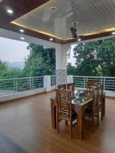 a dining room with a table and chairs on a balcony at Dreamland Resort in Nainital