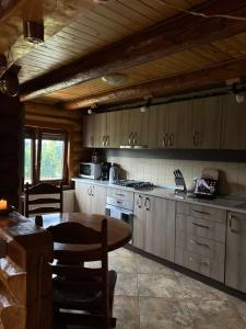 a kitchen with a table and a stove and cabinets at Casa Brindusa in Poiana Negrii