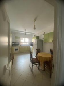 una cocina con mesa y algunas sillas y una mesa y una cocina con en Joujou Aprt, en Monastir