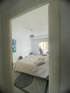 1 dormitorio con 1 cama a través de una puerta en Joujou Aprt, en Monastir