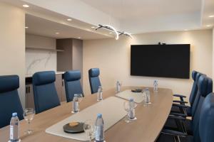 a conference room with a table and chairs and a tv at Royal Beach Hotel Punta Cana, A JdV by Hyatt in Punta Cana +20 photos