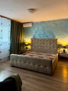 een slaapkamer met een groot bed met een groot schilderij aan de muur bij SHoliday 1 Bedroom Balcony &Free Parking in Timişoara