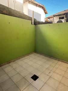 Zimmer mit grüner Wand und Fliesenboden in der Unterkunft Bosque y mar in Necochea