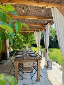 a wooden table with chairs under a wooden pergola at Berkenye Vendégház Tisza-tó in Abádszalók