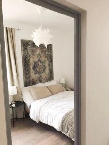 a bedroom with a white bed and a mirror at Berkenye Vendégház Tisza-tó in Abádszalók