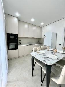 a kitchen with a table and chairs and a refrigerator at Arena Park apartments in Almaty