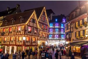a crowd of people walking down a street with christmas lights at Au petit Logelbach in Wintzenheim