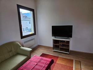 a living room with a couch and a flat screen tv at Ferienwohnung Villach Süd in Villach