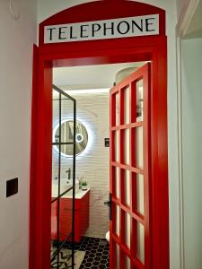 eine rote Tür, die in ein Badezimmer mit Waschbecken führt in der Unterkunft fruit tower in Thessaloniki