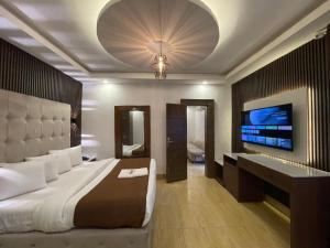 a bedroom with a large bed and a flat screen tv at Presken Residence in Ikeja +27 photos