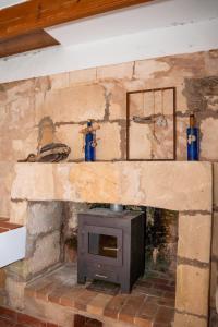 a stone fireplace with a stove in a room at Isla privada, Menorca in Fornells