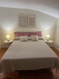 a bedroom with a large bed with two lamps at Casa Alan in Burriana