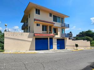 a house with blue doors on the side of a street at Preciosa casa para Descanso en Tequesquitengo in Tequesquitengo
