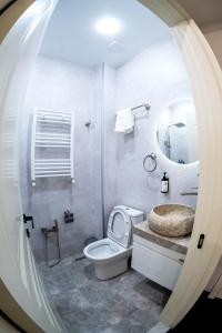 a bathroom with a toilet and a sink and a mirror at Hotel Urban Bliss in Tbilisi City
