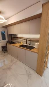 a kitchen with white cabinets and a sink at Krisman Residence 3 in Piteşti
