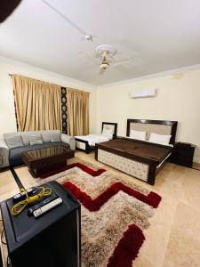 a living room with a bed and a couch at New Pak Guest House in Islamabad