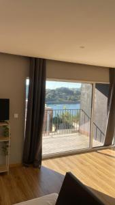 a living room with a large window and a balcony at Porto Vista Douro Apart in Valbom +3 photos