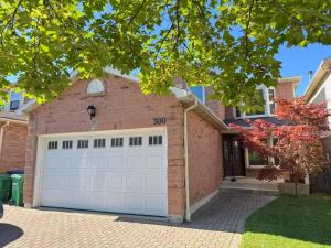 una casa de ladrillo con una puerta de garaje blanca en Stylish Mississauga Escape Near Downtown, en Mississauga
