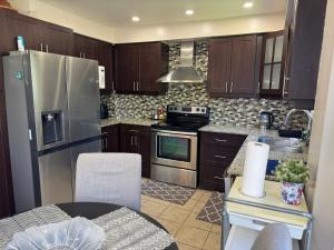 a kitchen with wooden cabinets and a stainless steel refrigerator at Stylish Mississauga Escape Near Downtown in Mississauga +62 photos
