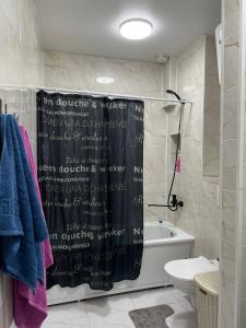 Baño con cortina de ducha con escritura en Квартира посуточно в элитном ЖК, en Zhezdi 13 fotos más