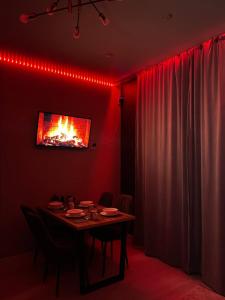 comedor con mesa y TV en la pared en Квартира посуточно в элитном ЖК, en Zhezdi